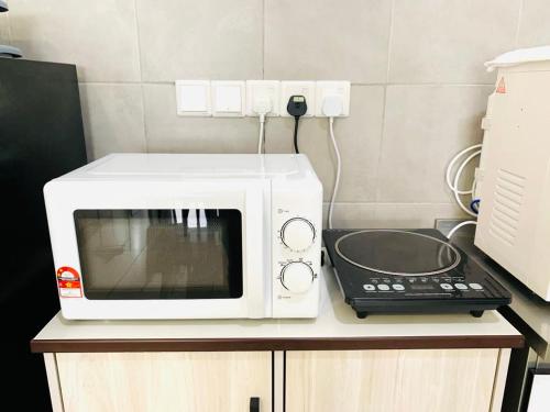 a white microwave sitting on top of a kitchen counter at 4BR M Vertica near Sunway Velocity Cheras IKEA MRT TRX KLCC Pavilion in Kuala Lumpur