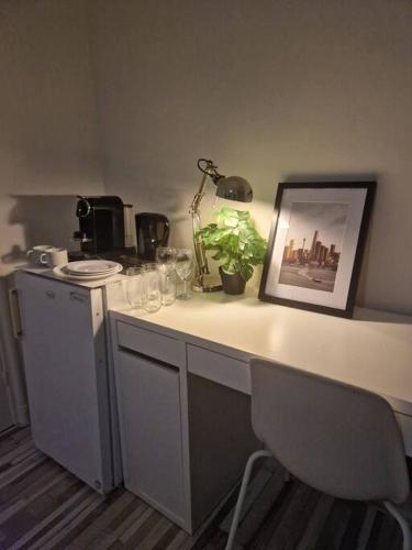 a white desk with a picture and a plant on it at Cozy Private Room 5 on a Busy Persian Restaurant in Eindhoven