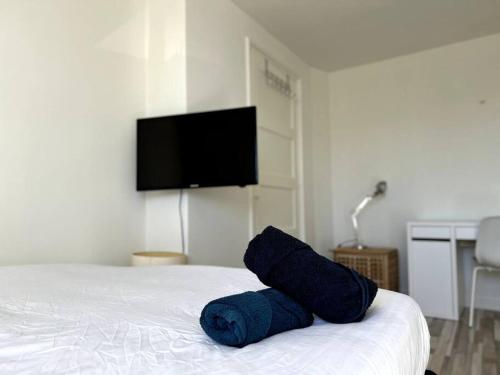 Room 505 - Eindhoven by T&S في أيندهوفن: منشفة زرقاء موضوعة على سرير مع تلفزيون