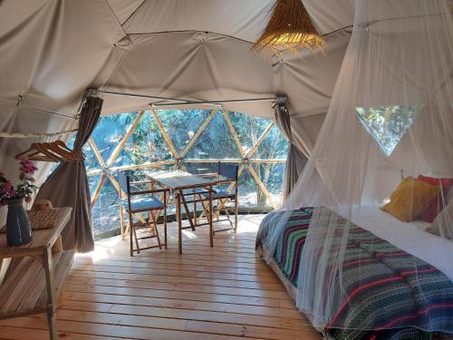 um quarto com uma cama e uma mesa numa tenda em Salema Eco Camp - Sustainable Camping & Glamping em Salema