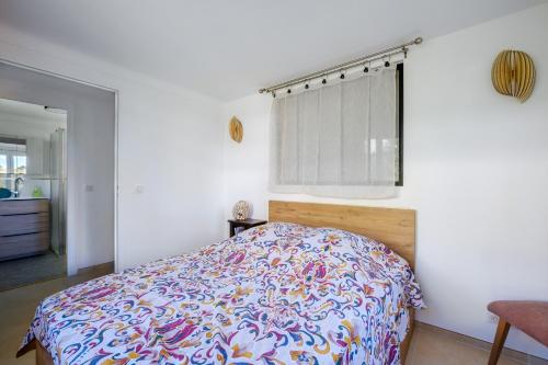 a bedroom with a bed with a colorful bedspread at Jolie maison Lucéram in Lucéram