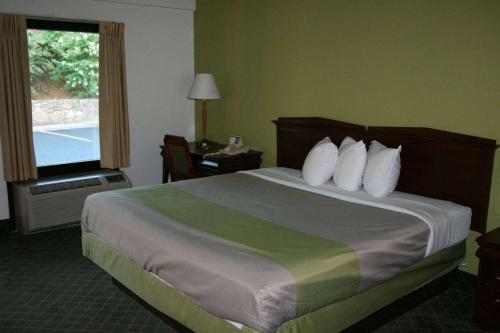 a hotel room with a bed and a window at Travelodge by Wyndham Roanoke in Roanoke
