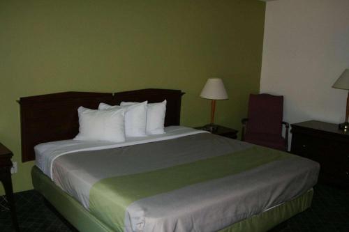 a hotel room with a large bed with white pillows at Travelodge by Wyndham Roanoke in Roanoke