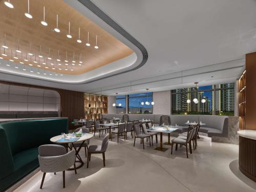un restaurant avec des tables, des chaises et des fenêtres dans l'établissement Doubletree By Hilton Nanning Wuxiang, à Nanning