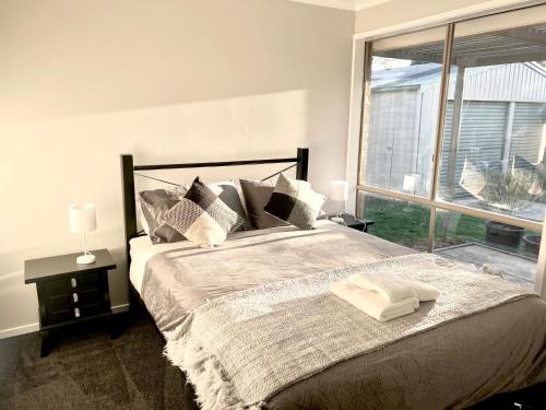een slaapkamer met een groot bed en een groot raam bij Geelong Bellarine Coastal Stays#Pet Friendly in Clifton Springs