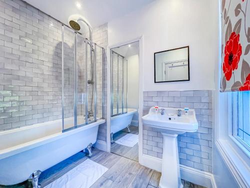 a bathroom with a sink and a tub and a toilet at *RA9bC* For your most relaxed & Cosy stay + Free Parking + Free Fast WiFi * in Moortown