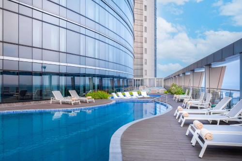 une piscine avec des chaises longues et un bâtiment dans l'établissement Hilton Kinshasa, à Kinshasa