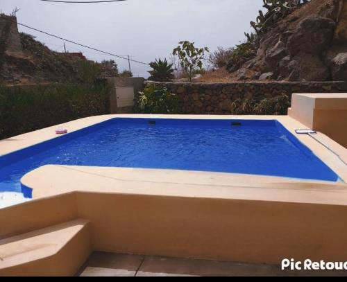 una piscina con agua azul en un patio trasero en Casa Cueva en Arafo, en Santa Cruz de Tenerife