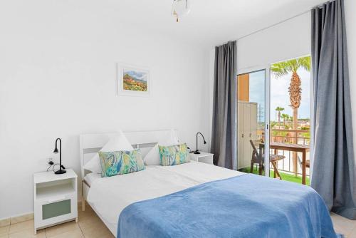 カジャオ・サルバヘにあるVista la Gomera 2の白いベッドルーム(ベッド1台、バルコニー付)