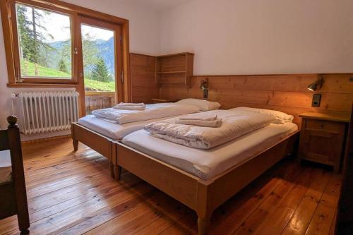 großes Berg-Chalet in der Natur في بايريشزيل: سريرين توأم في غرفة مع نافذة