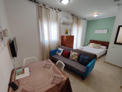 - un salon avec un canapé et un lit dans l'établissement Estudio en el centro, à Reus