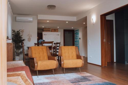 a living room with two chairs and a table at ROTA - Opo airport house in Maia