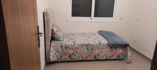 a small bed in a bedroom with a window at APPARTEMENT haut standing in Ben Slimane