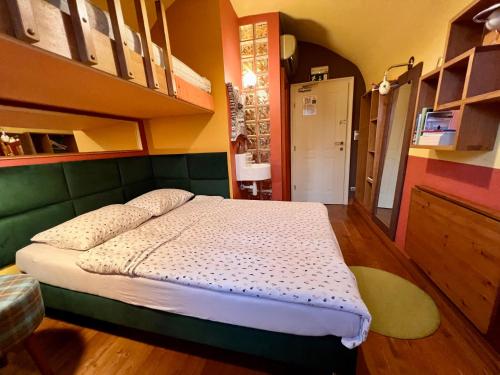 a bedroom with a bed with a green headboard at MuziKafe - Home of Culture in Ptuj