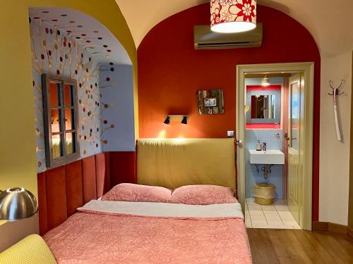 a bedroom with a bed and a bathroom with a sink at MuziKafe - Home of Culture in Ptuj