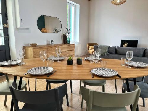 a wooden table with glasses and chairs in a living room at L'évasion - Terrasse privée in La Rochelle