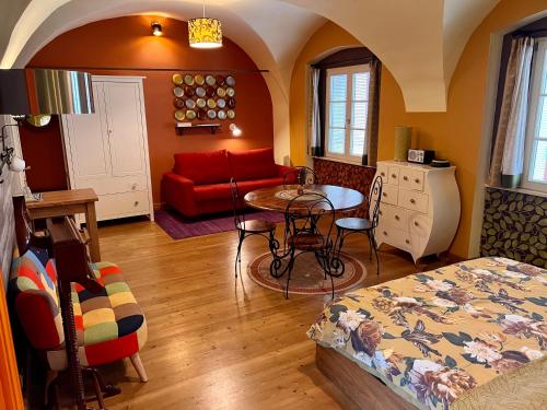a living room with a red couch and a table at MuziKafe - Home of Culture in Ptuj