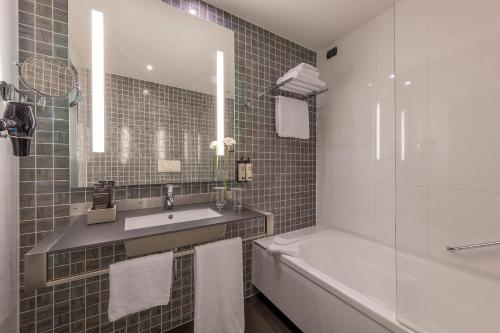 a bathroom with a sink and a tub and a shower at H10 Roma Città in Rome
