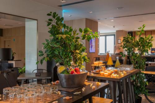 a table with a potted plant on top of it at H10 Roma Città in Rome