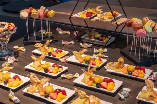 a table with a bunch of desserts on plates at H10 Roma Città in Rome