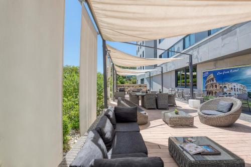a patio with couches and chairs on a building at H10 Roma Città in Rome