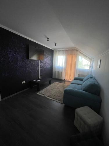 a living room with a blue couch and a window at Sara’S Apartament in Suceava