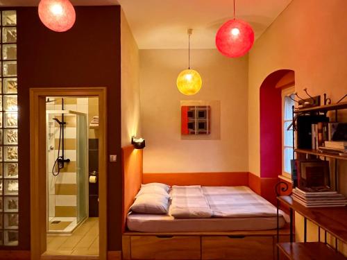 a room with a bed and two pendant lights at MuziKafe - Home of Culture in Ptuj