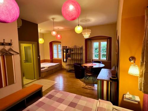 a living room with a bed and a room with a table at MuziKafe - Home of Culture in Ptuj