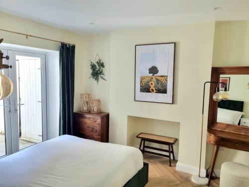 een slaapkamer met een bed, een tafel en een spiegel bij Spacious & Renovated 1-Bed Garden Flat in London in Londen