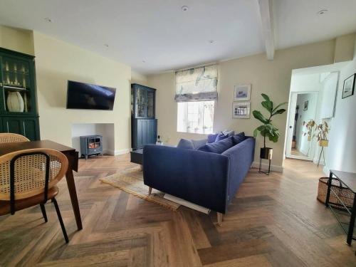 a living room with a blue couch and a table at Spacious & Renovated 1-Bed Garden Flat in London in London