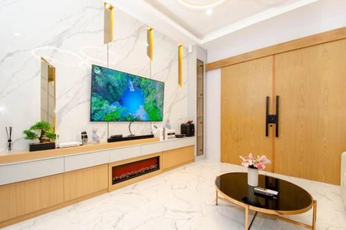 a living room with a tv on a wall at Phirom pool villa pattaya in Nong Prue