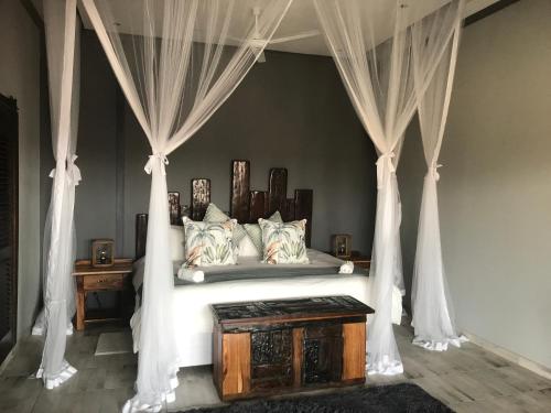 a bedroom with a canopy bed with curtains at Mababe River Lodge in Mababe
