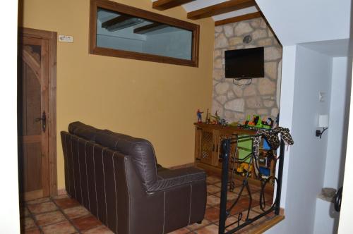 a living room with a leather chair and a television at Las Abadías in San Felices