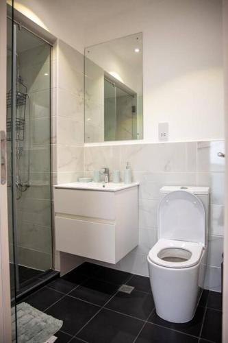 a bathroom with a toilet and a sink and a shower at Sunrise Loft @Embassy Gardens (75sqm) in Cantonments