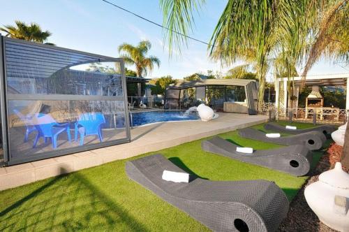 une maison avec une piscine et une cour avec de l'herbe dans l'établissement בקתות גן עדן, à Kallanit