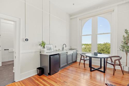 a white kitchen with a table and a sink at The McKey in Valdosta