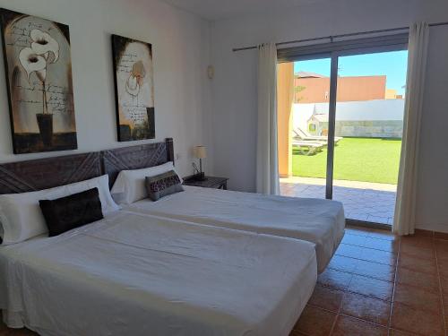 a bedroom with two beds and a sliding glass door at VILLA PARADISE in La Guirra