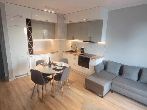 a kitchen and a living room with a table and a couch at Katowice Sokolska Towers in Katowice