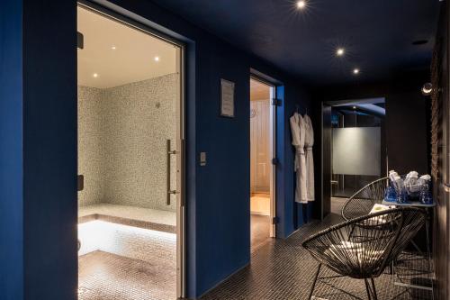 a blue bathroom with a tub and a glass door at Hotel Mademoiselle in Paris