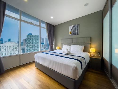 1 dormitorio con 1 cama grande y ventanas grandes en Vortex KLCC Suites by Homestay en Kuala Lumpur