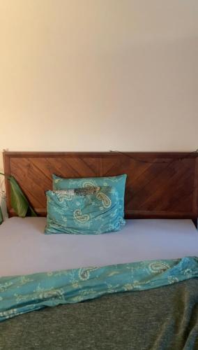 a bed with a wooden headboard and a blue pillow at Rooftop Apartment - Zurich Airport in Zurich