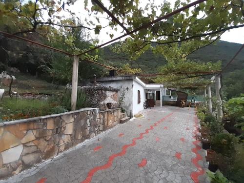 Una casa con una pasarela de piedra con pintura roja. en Appartament Dukat Albania 2 en Dukat