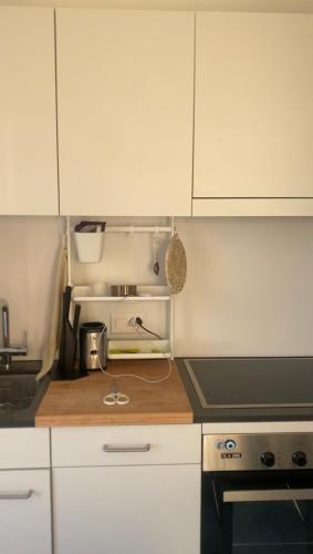 a kitchen with white cabinets and a counter top at Rooftop Apartment - Zurich Airport in Zurich