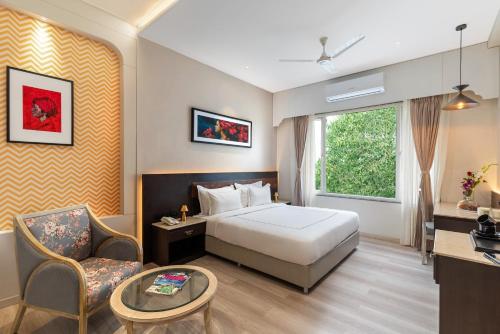 a hotel room with a bed and a chair at City Connect by Downtown Udaipur in Udaipur