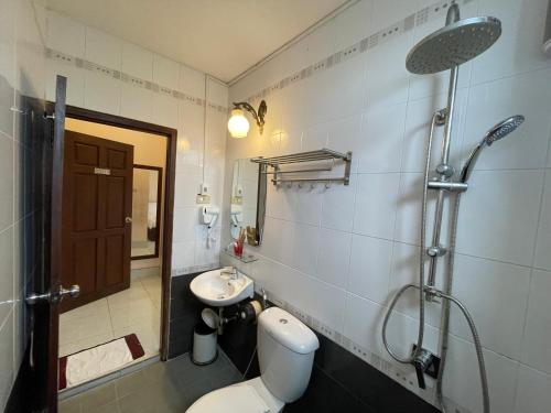 a bathroom with a toilet and a sink and a shower at Hoang Kim Hotel in Vientiane