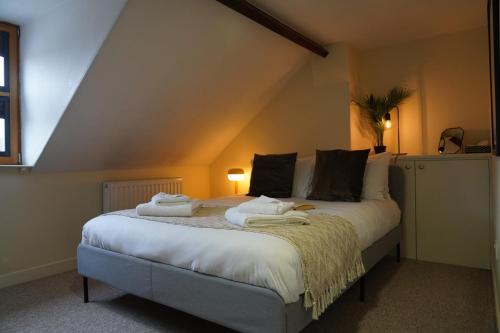 1 dormitorio con 1 cama con toallas en Woodstock Oxford Street- Entire Cosy Apartment- 5 mins to Blenheim Palace en Woodstock