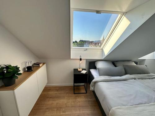 een slaapkamer met een bed en een raam bij Stylisches Apartment in zentraler Lage - mit Klima in Karlsruhe