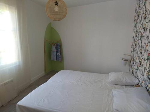 ein Schlafzimmer mit einem weißen Bett und einem Fenster in der Unterkunft Gîte de La Promenade - proche du Zoo de Beauval in Valençay