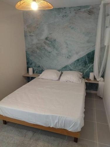 a bedroom with a bed with a painting on the wall at Gîte de La Promenade - proche du Zoo de Beauval in Valençay