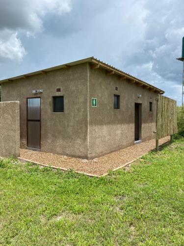 a large building with two doors in a yard at Mababe River Campsite in Mababe